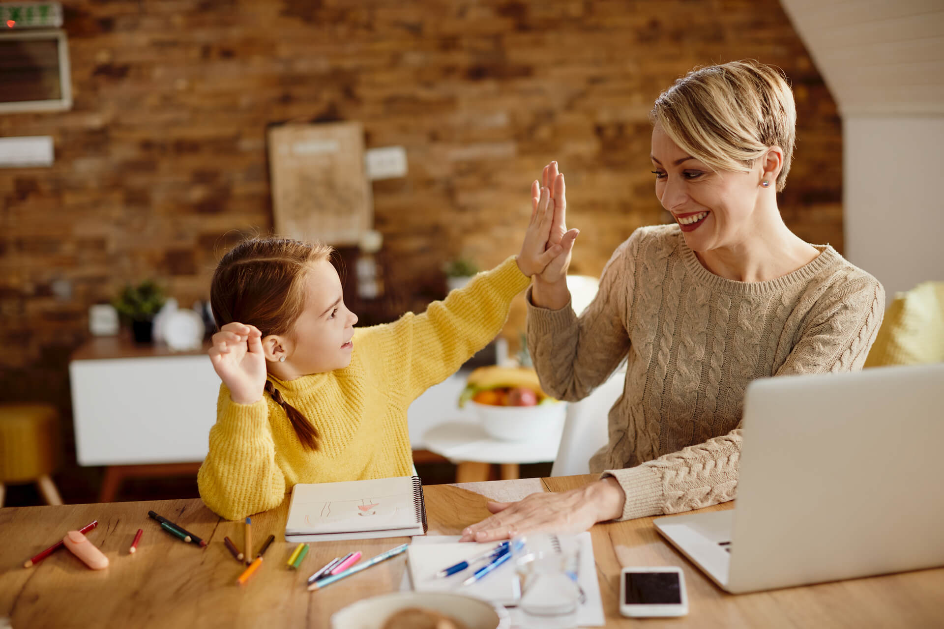 happy-mother-daughter-giving-highfive-during-homeschooling