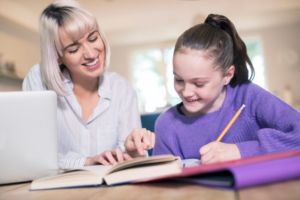 Female Home Tutor Helping Young Girl With Studies