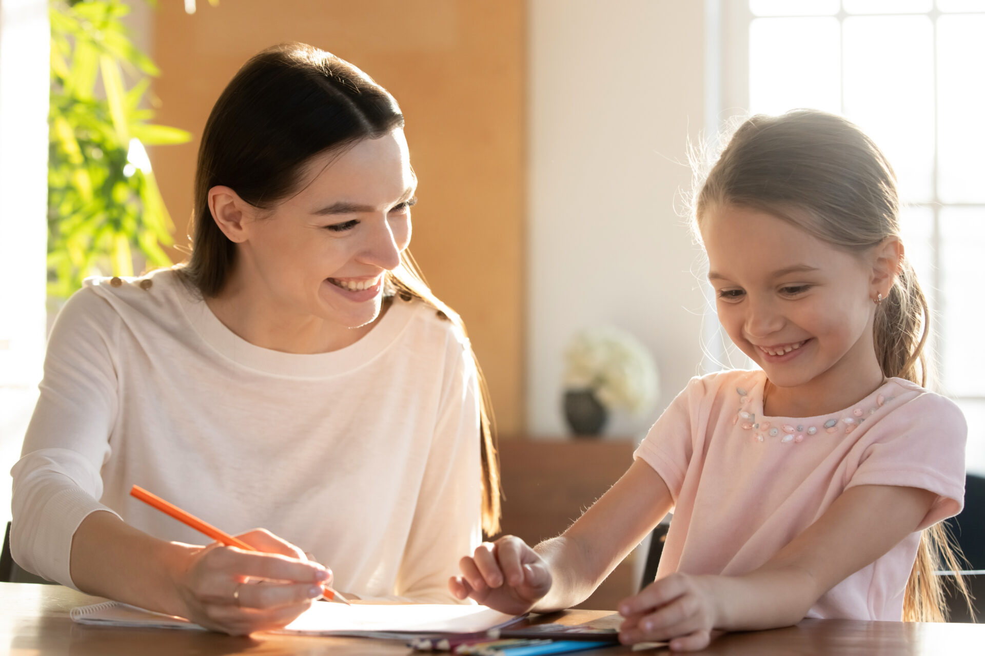 Young nanny tutor educating little preschool child girl.